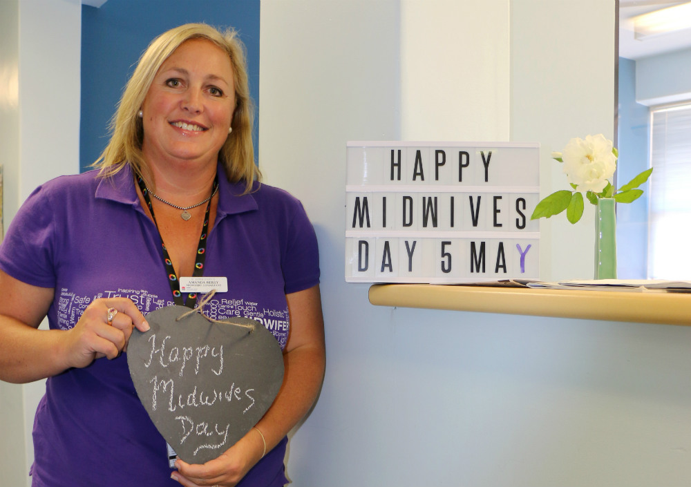 Midwife holding sign saying Happy Midwives Day