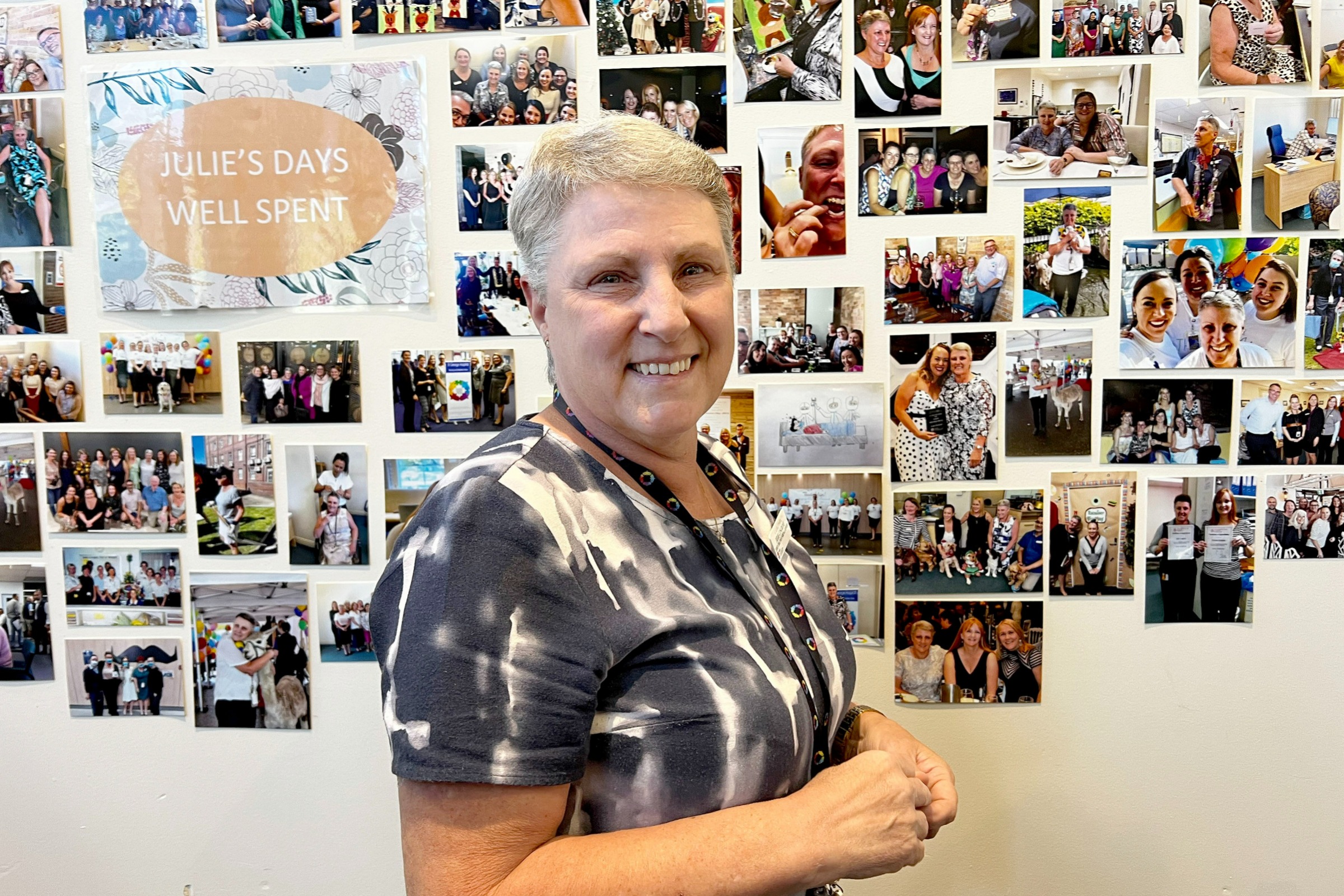 Julie Cosgrove standing in front of a wall of photos