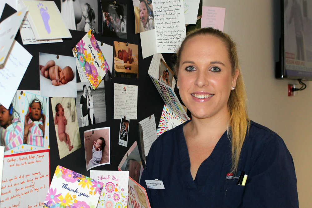 Caitlyn Tarrant in front of board with baby photos 