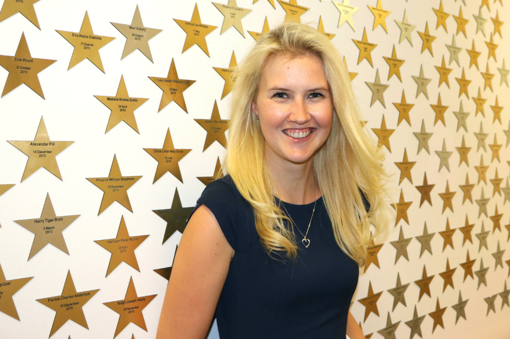 Woman standing in front of wall covered in stars