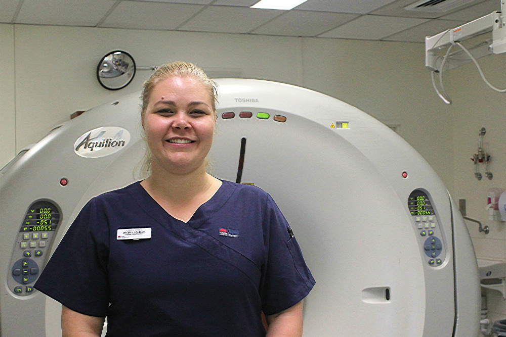 Nurse standing in front of medical imaging machine