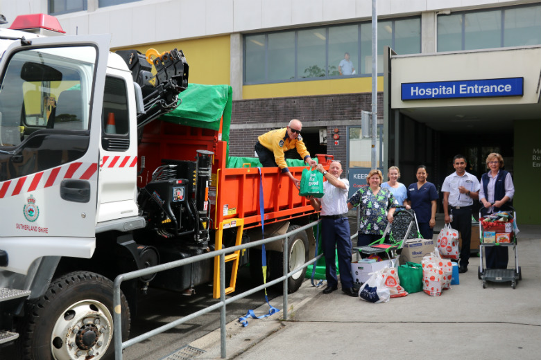 Group of hospital workers standing next to truck with Christmas presents