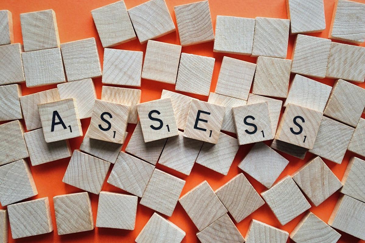 Scrabble tiles spelling out 'assess''