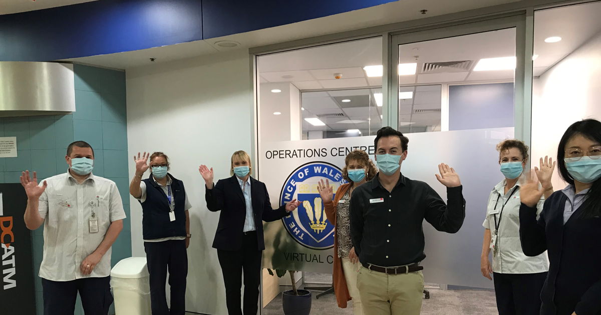 Staff in masks waving 