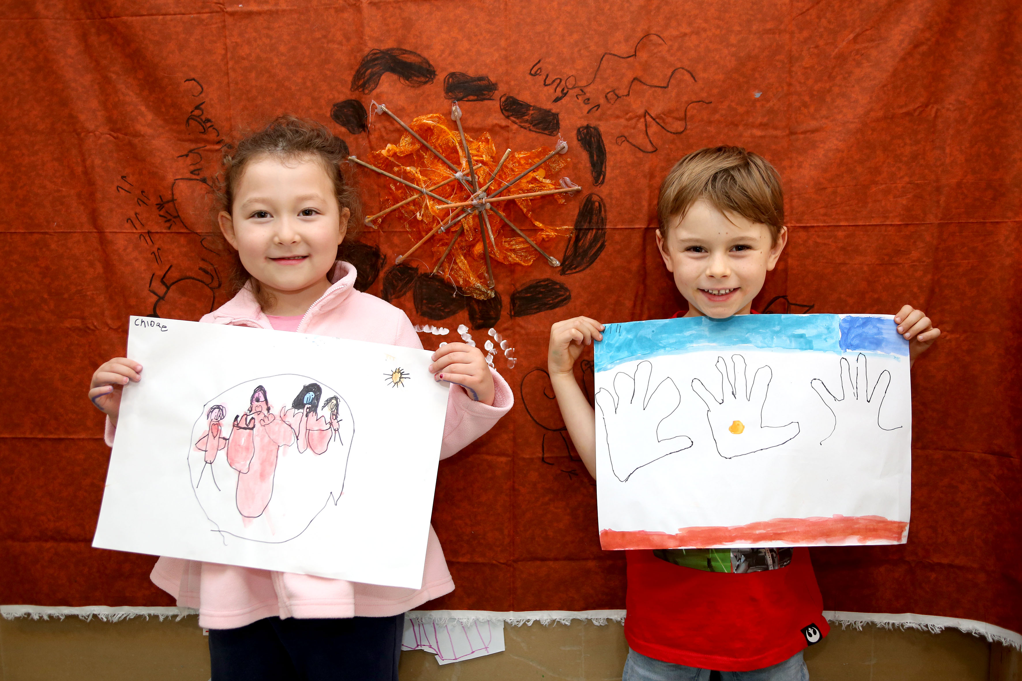 Children holding up artwork